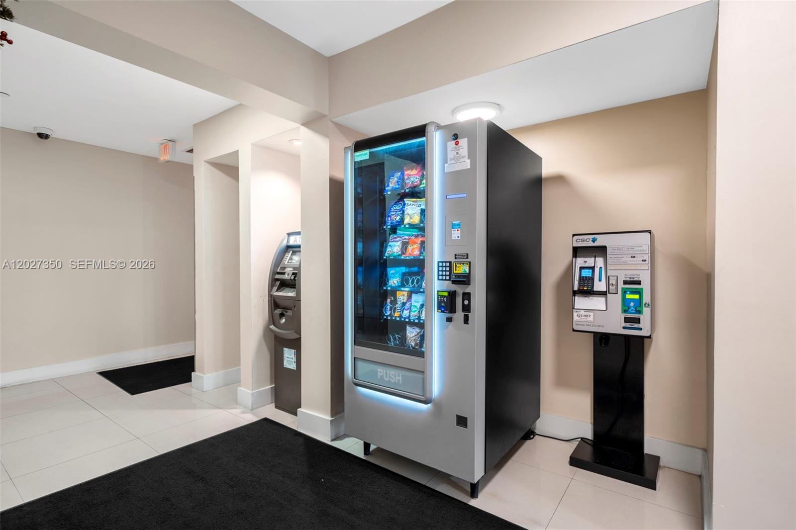 A vending machine and a payment kiosk are located in a tiled indoor hallway — 3301 NE 5th Ave # 608, Miami FL 33137, MIAMI, FL