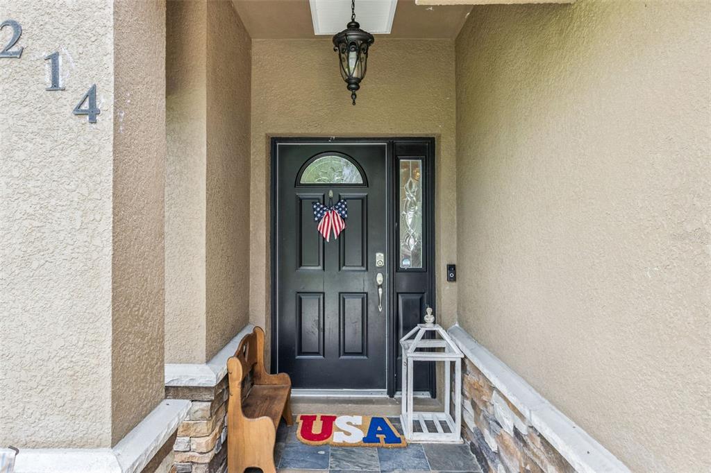 A front entryway features a black door with a decorative wreath and a stone base — 214 MOUNTAIN DRIVE, BABSON PARK, FL