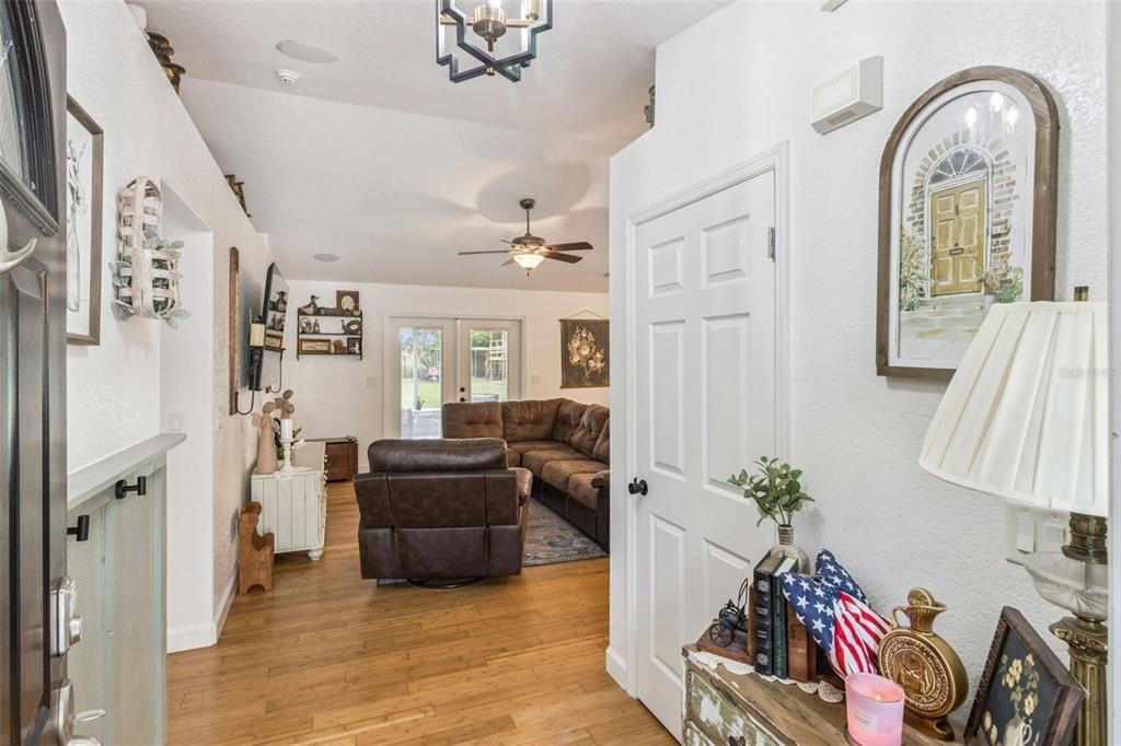 A view from an entryway looking into a living room with wood flooring and furniture — 214 MOUNTAIN DRIVE, BABSON PARK, FL