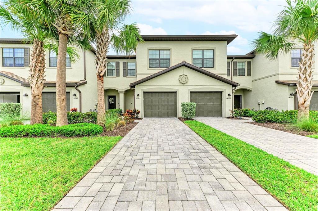 The exterior of a two-story townhouse with a paved driveway and two garage doors — 14767 LYLA TERRACE, LAKEWOOD RANCH, FL