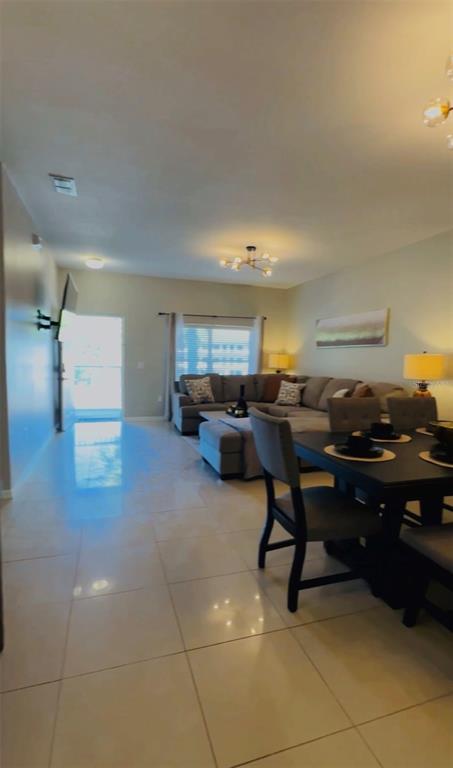 A living and dining area features tile flooring, a sectional sofa, and a dining table — 3107 SUN LAKE COURT UNIT B, KISSIMMEE, FL