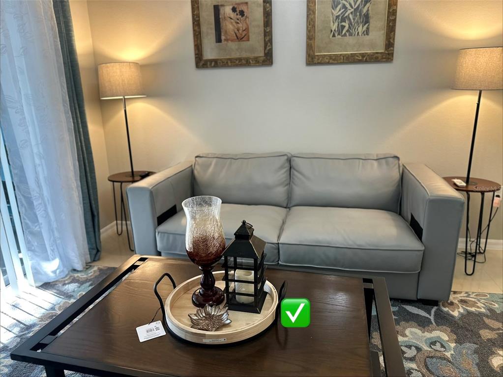 A living room features a grey sofa, a wooden coffee table, and two floor lamps — 3107 SUN LAKE COURT UNIT B, KISSIMMEE, FL
