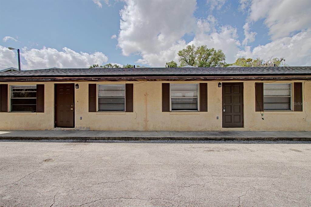 The exterior of a single-story apartment building features two brown doors and three windows — 830 N CLAKE STREET, DELAND, FL