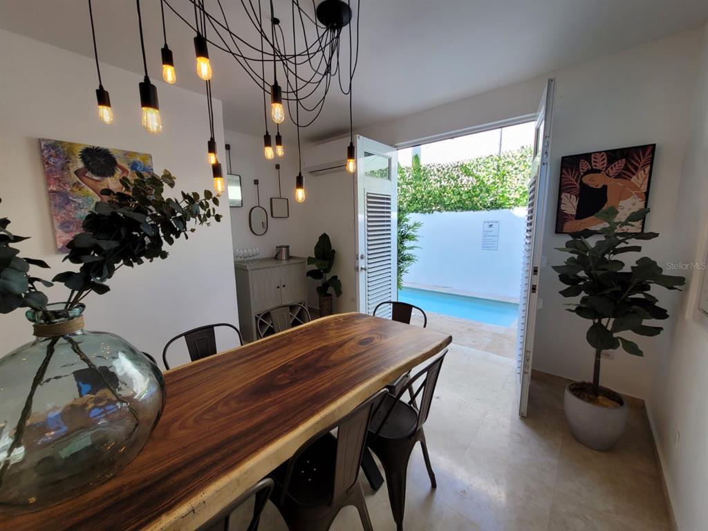 A dining room with a live-edge wood table, pendant lights, and a view of a pool — 2301 SOLDADO CRUZ, SAN JUAN, PR