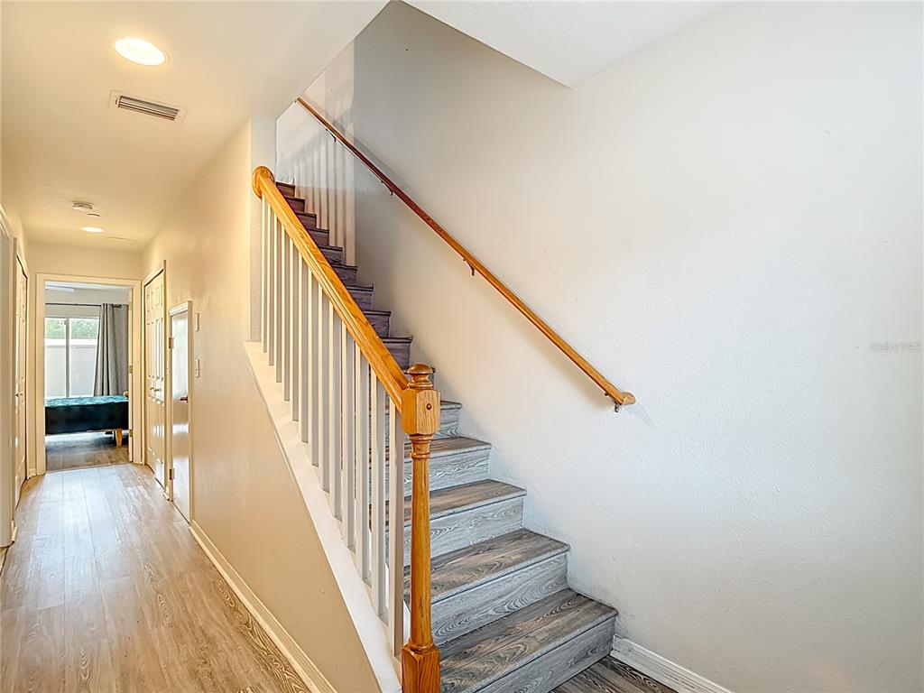 A staircase with wood-look treads and a white railing leads upward in a hallway — 2426 MIDDLETON GROVE DRIVE, BRANDON, FL