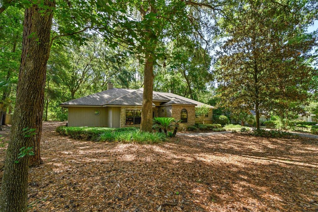 A house exterior features a stone and siding facade, a two-car garage, and a paver driveway — 4427 SW 84TH WAY, GAINESVILLE, FL