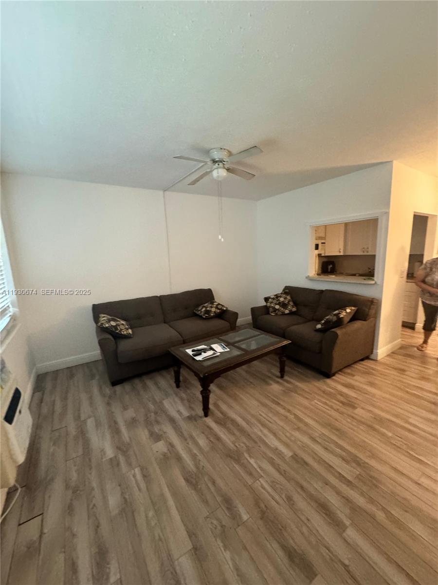 A living room features two dark sofas, a coffee table, and light wood-look flooring — 118 E Salisbury  E # 118, West Palm Beach FL 33417, WEST PALM BEACH, FL