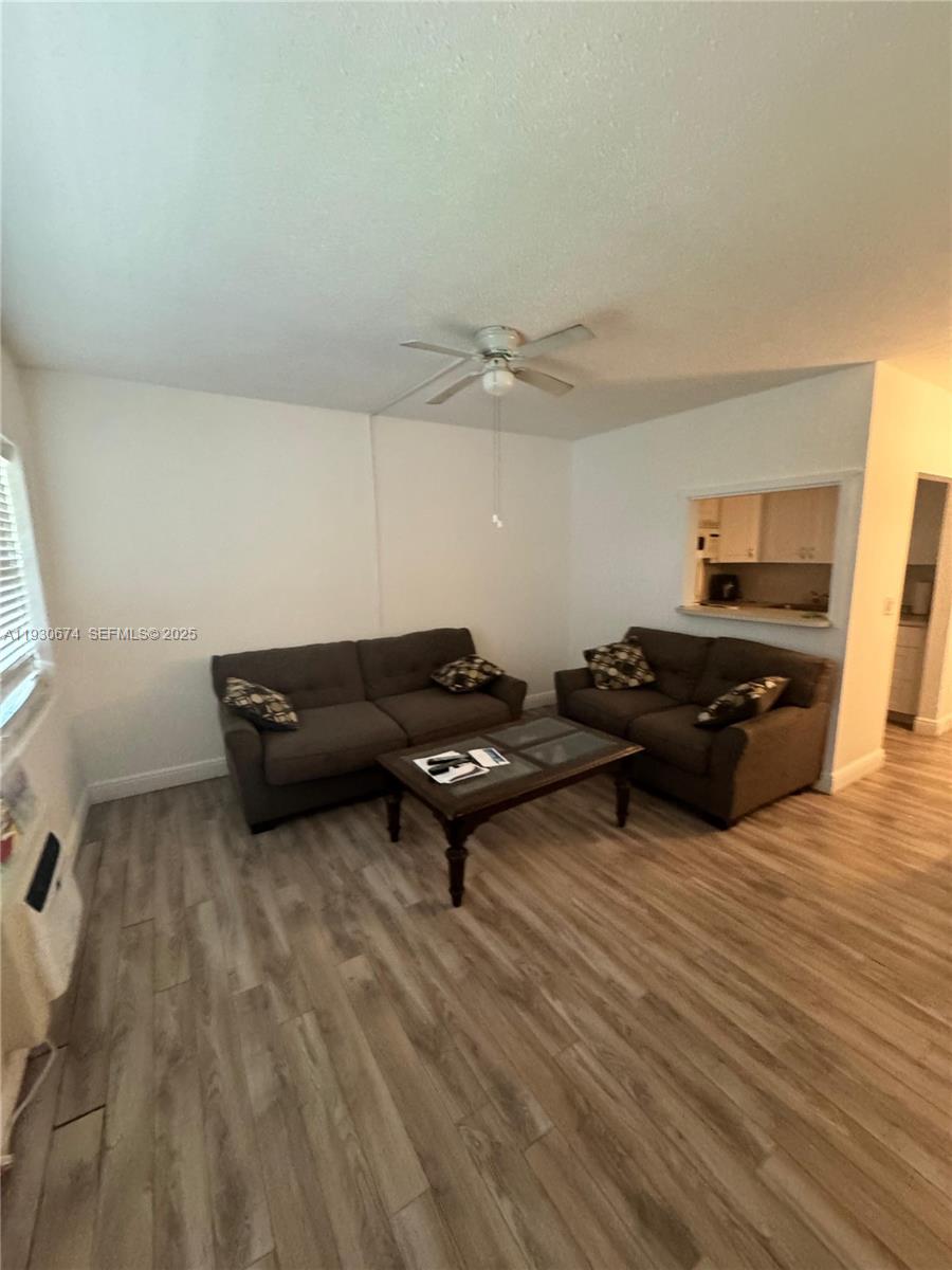 A living room features two gray sofas, a coffee table, and light wood-look flooring — 118 E Salisbury  E # 118, West Palm Beach FL 33417, WEST PALM BEACH, FL