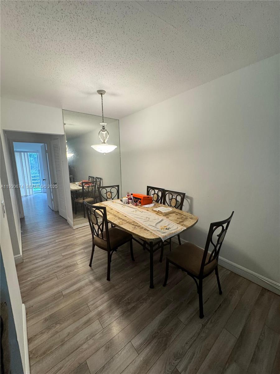A dining area features a stone-topped table, metal chairs, and a large wall mirror — 118 E Salisbury  E # 118, West Palm Beach FL 33417, WEST PALM BEACH, FL