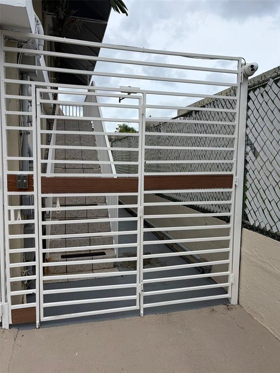 A white metal security gate stands at the base of an outdoor tiled staircase — 859 CALLE MARGINAL, SAN JUAN, PR