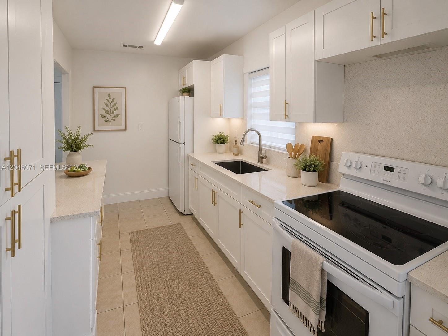 A bright kitchen features white cabinetry, gold hardware, quartz countertops, and stainless steel appliances — 3810 SW 89th Ave # 3810, Miami FL 33165, MIAMI, FL
