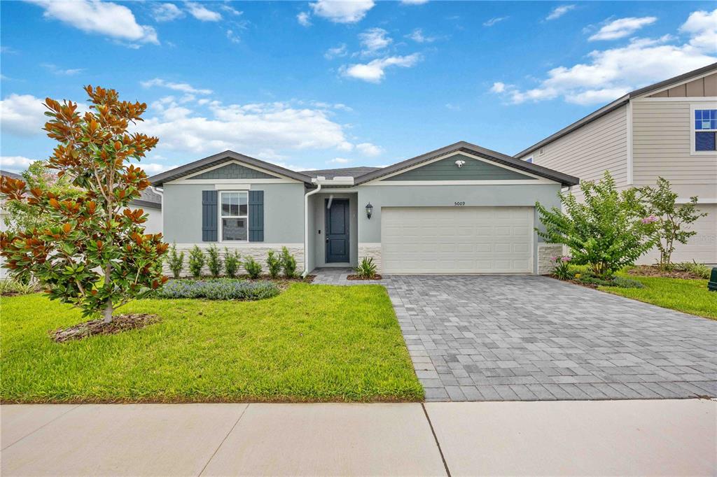 A single-story house with a light green exterior, a two-car garage, and a paved driveway — 5009 KATRINA DRIVE, HAINES CITY, FL