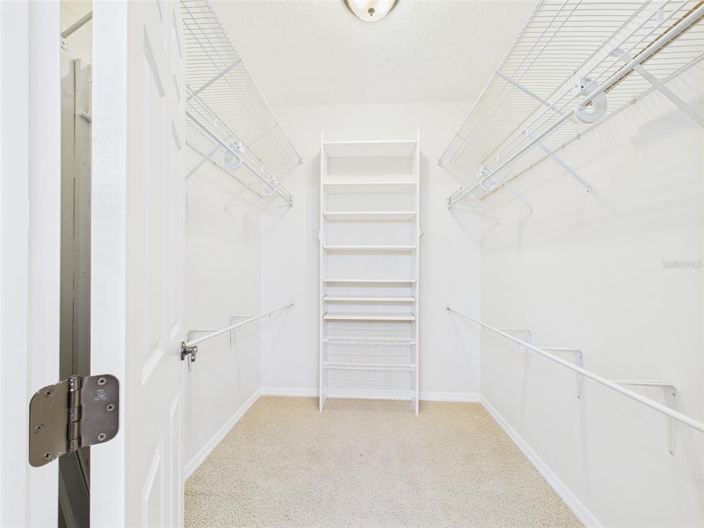 A bathroom features a double vanity, a glass-enclosed shower, and a walk-in closet — 375 SIMPSON STREET, THE VILLAGES, FL