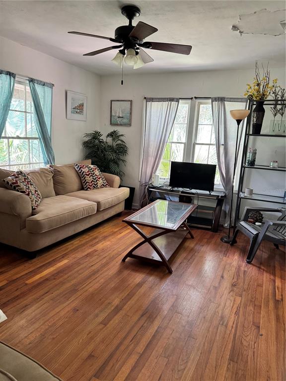 A living room features hardwood floors, a beige sofa, a coffee table, and a ceiling fan — 1119 NW 25TH AVENUE, GAINESVILLE, FL