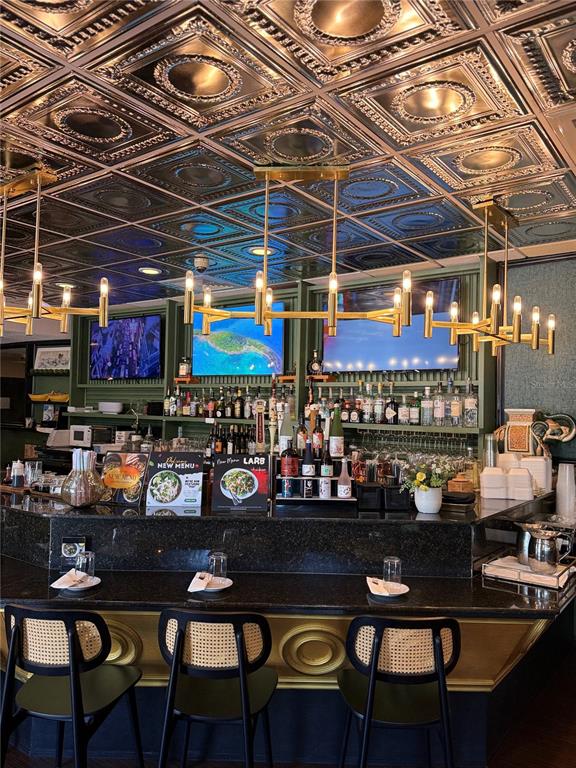 A bar area features a black countertop, cane-back stools, and a decorative metallic ceiling — 7900 4TH ST N STREET, ST PETERSBURG, FL