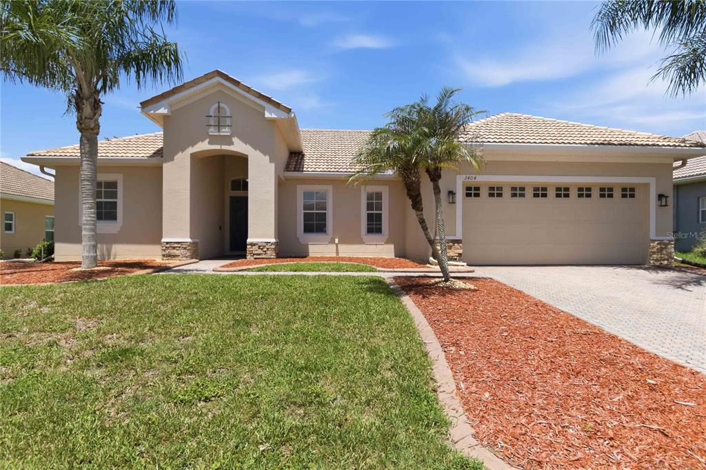 A single-story house with a beige stucco exterior, a tiled roof, and a paved driveway — 3404 GREAT POND DRIVE, KISSIMMEE, FL
