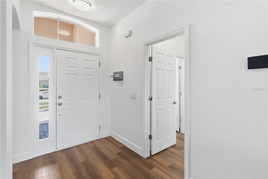 An entryway features a white front door, wood-look flooring, and an open interior doorway — 3404 GREAT POND DRIVE, KISSIMMEE, FL