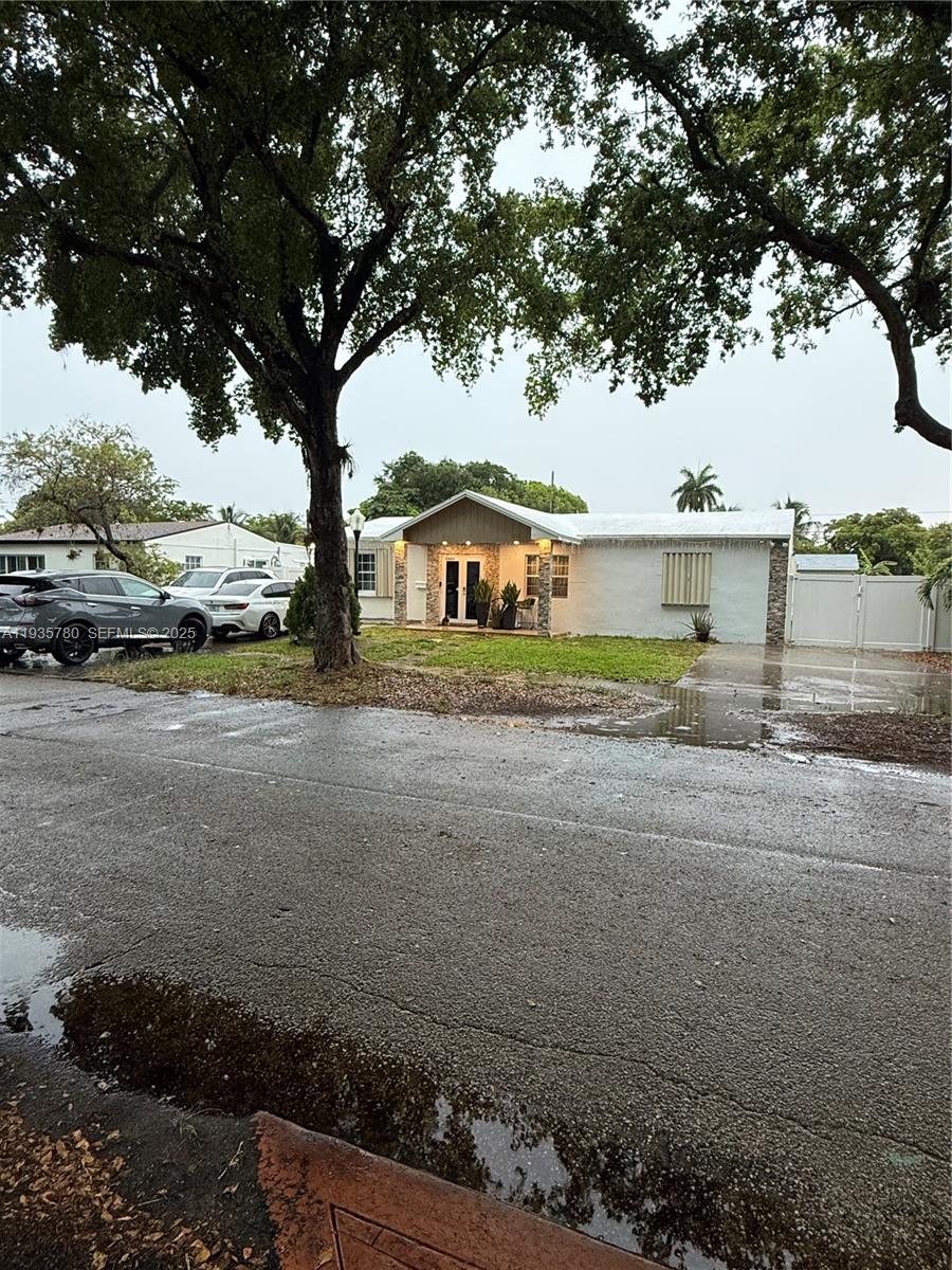 A single-story house with a gabled entrance, stone accents, and a paved driveway — 1031 NE 142nd St, North Miami FL 33161, NORTH MIAMI, FL