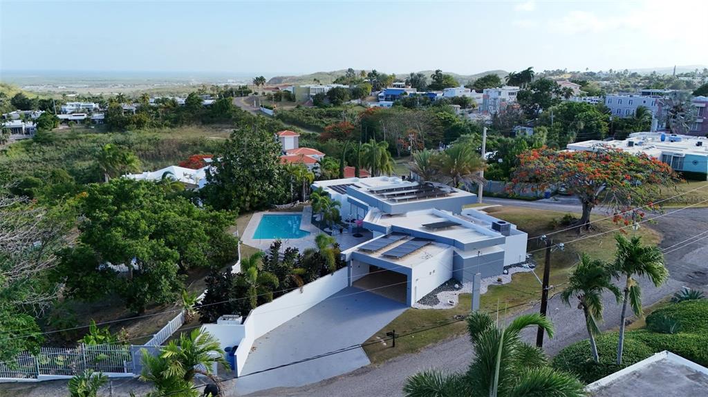 An aerial view shows a modern house with a swimming pool and solar panels — 3505 LA SANTA EL MONTE, PONCE, PR