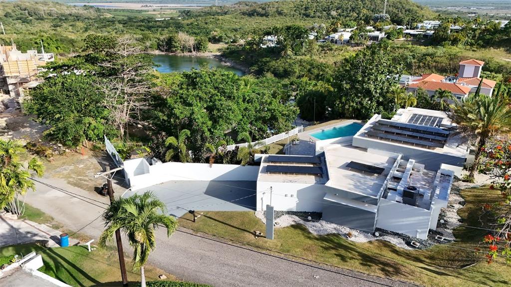 An aerial view of a modern white house with solar panels and a swimming pool — 3505 LA SANTA EL MONTE, PONCE, PR