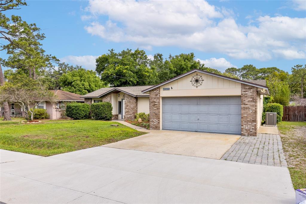 A single-story brick house with a two-car garage and a concrete driveway — 2707 BALKAN STREET, APOPKA, FL