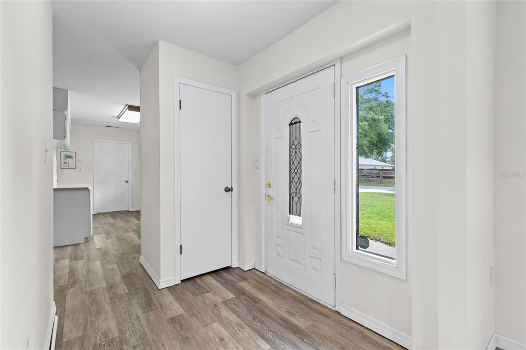 An entryway features wood-look flooring, a white front door with a window, and a closet — 2707 BALKAN STREET, APOPKA, FL