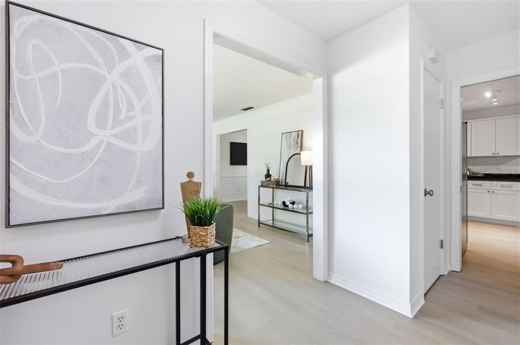 A bright entryway features light wood flooring, white walls, and a view into the kitchen — 4811 BERRYWOOD DRIVE, ORLANDO, FL