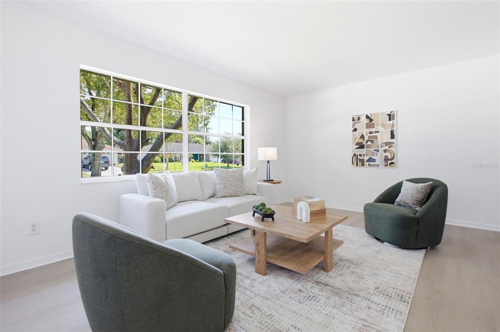 A bright living room features a white sofa, two green armchairs, and a wooden coffee table — 4811 BERRYWOOD DRIVE, ORLANDO, FL