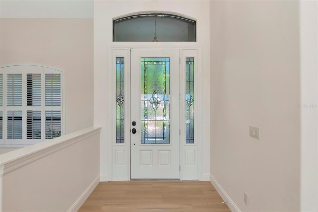 A white front door with decorative glass panels and a transom window in a foyer — 2012 ISLAND ESTATES DRIVE, PARRISH, FL