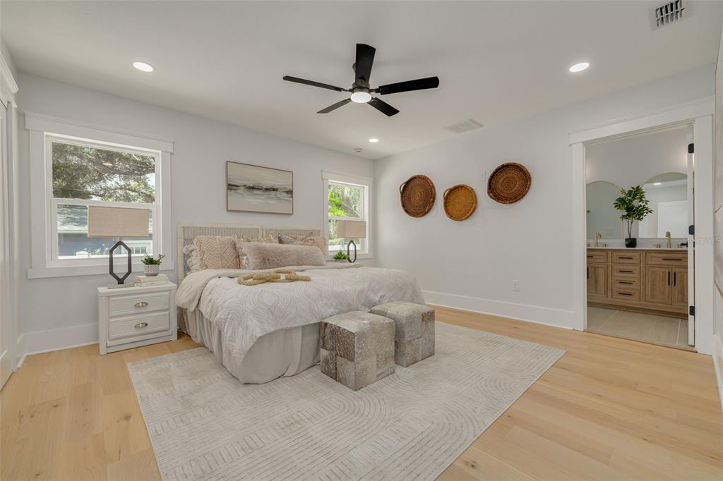 A bedroom with light wood floors, a ceiling fan, and an attached bathroom — 1426 15TH STREET N, ST PETERSBURG, FL