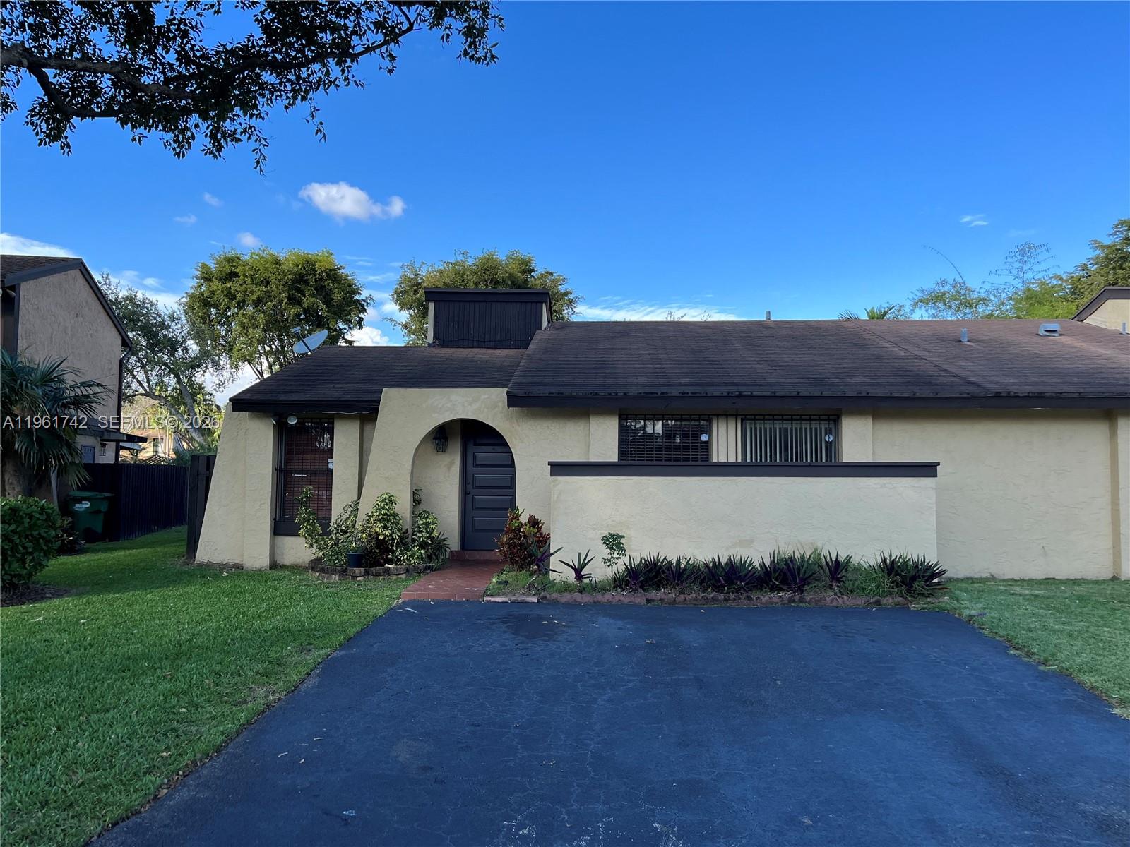 A single-story house with a dark brown roof, stucco exterior, and a paved driveway — 12713 SW 70th Ln, Miami FL 33183, MIAMI, FL