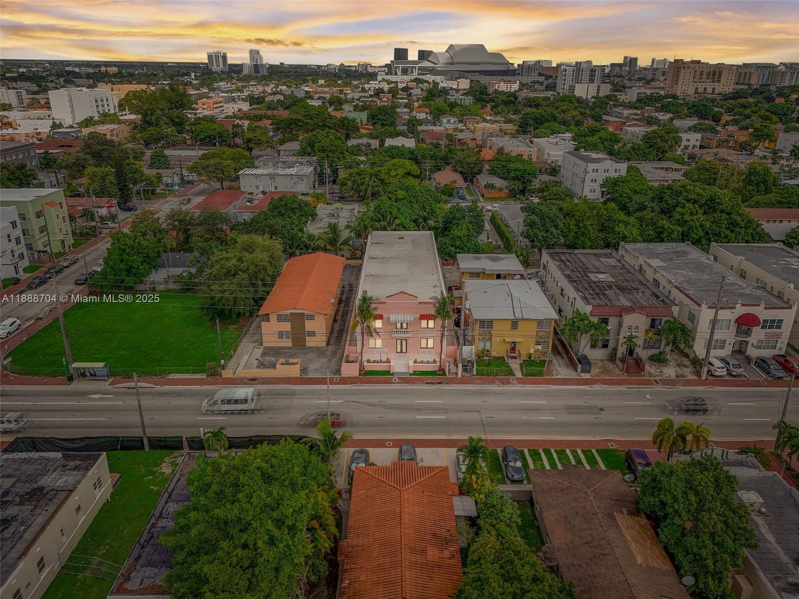 An aerial view shows a pink apartment building surrounded by urban residential and commercial structures — 1553 SW 7th St, Miami FL 33135, MIAMI, FL