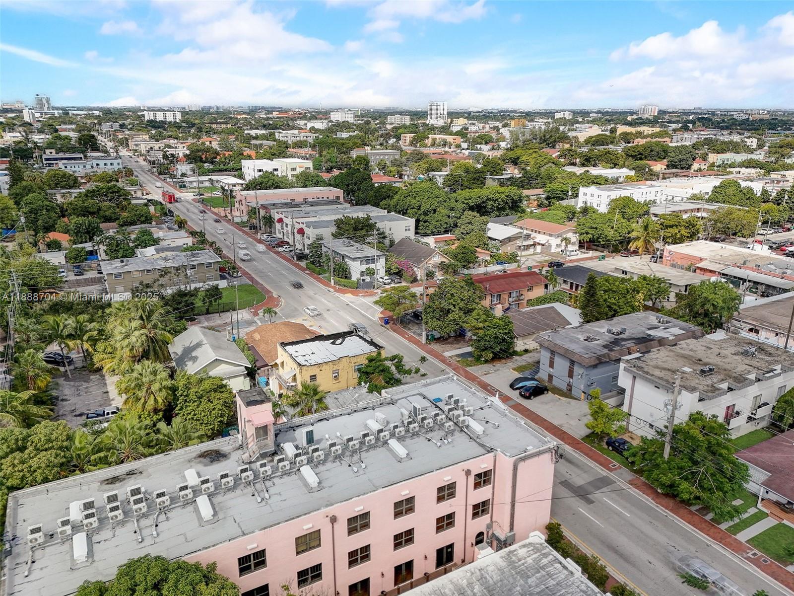 An aerial view shows a pink building, surrounding residential structures, and a street in Florida — 1553 SW 7th St, Miami FL 33135, MIAMI, FL