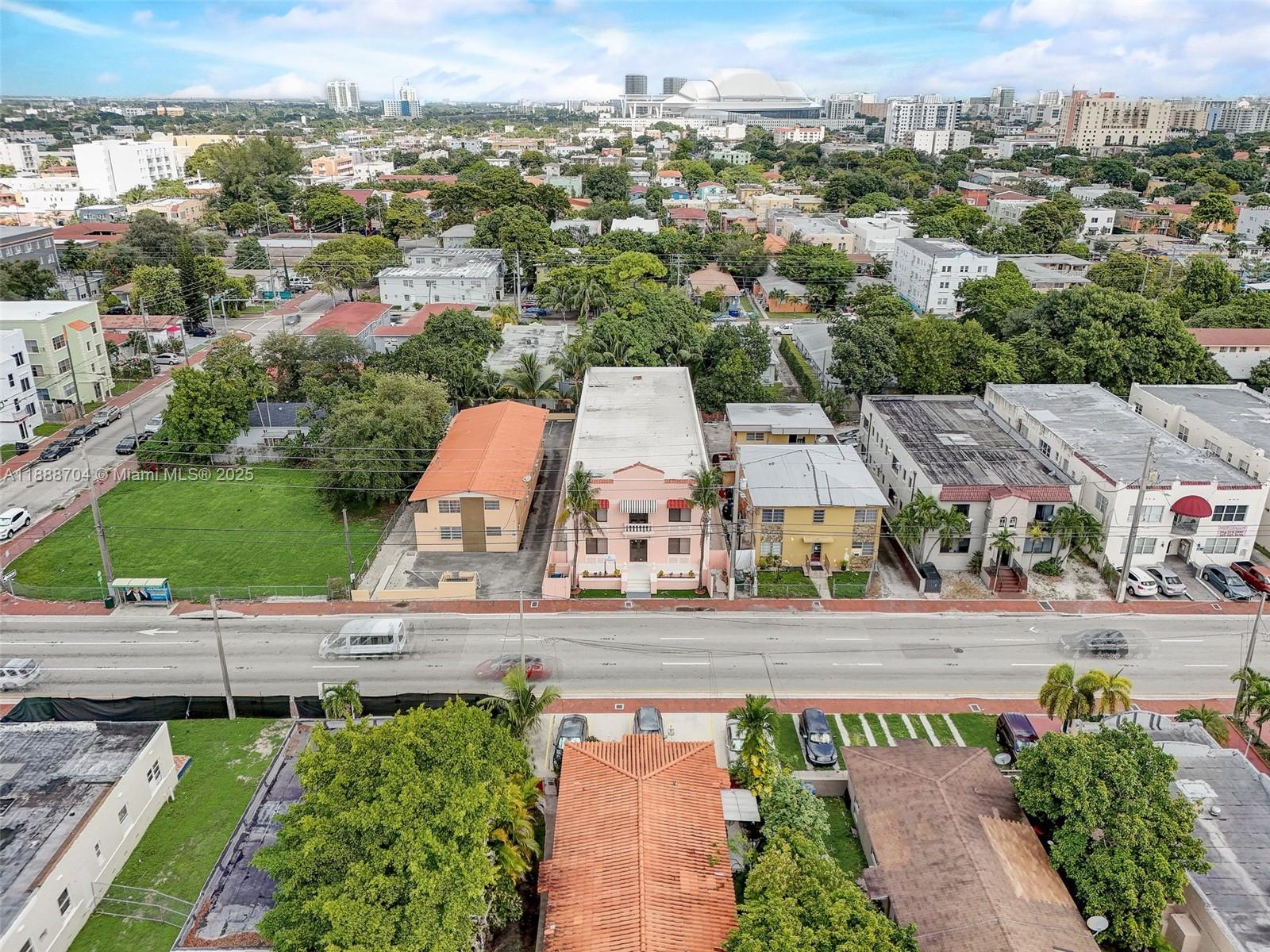 An aerial view shows a multi-story pink building surrounded by residential properties and city streets — 1553 SW 7th St, Miami FL 33135, MIAMI, FL