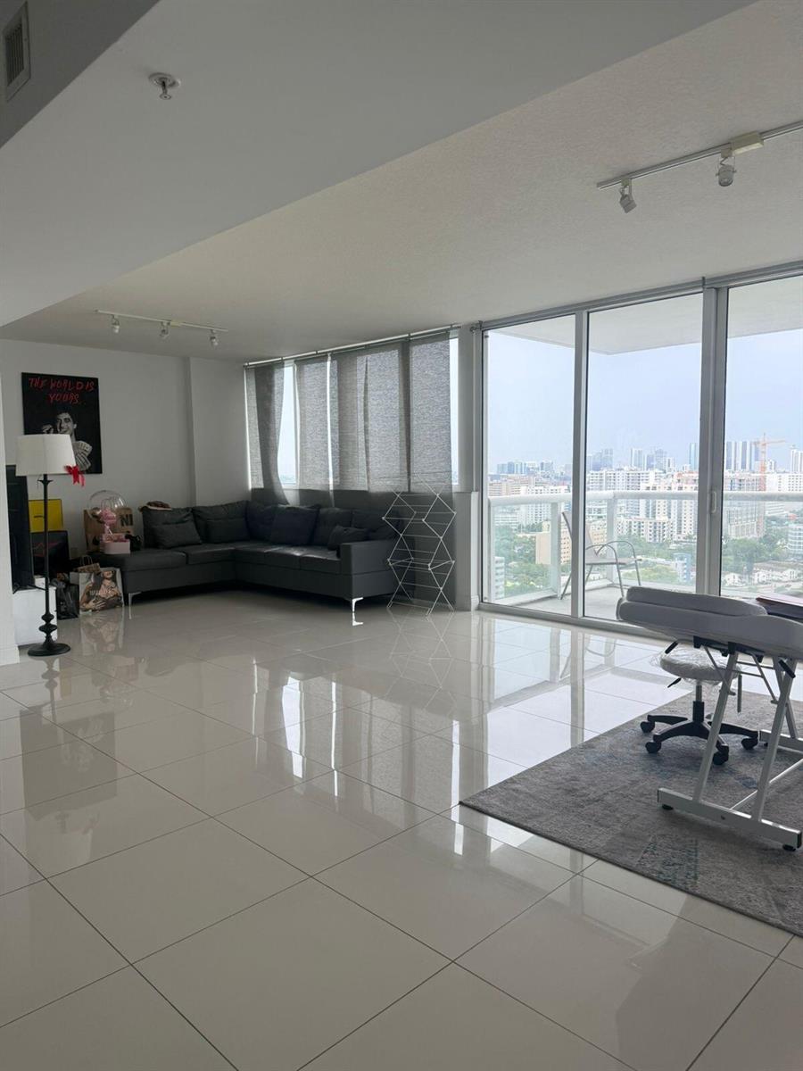 A modern living room with white tile floors, a gray sectional, and floor-to-ceiling windows — 1861 NW S River Drive # 2408, Miami FL 33125, MIAMI, FL