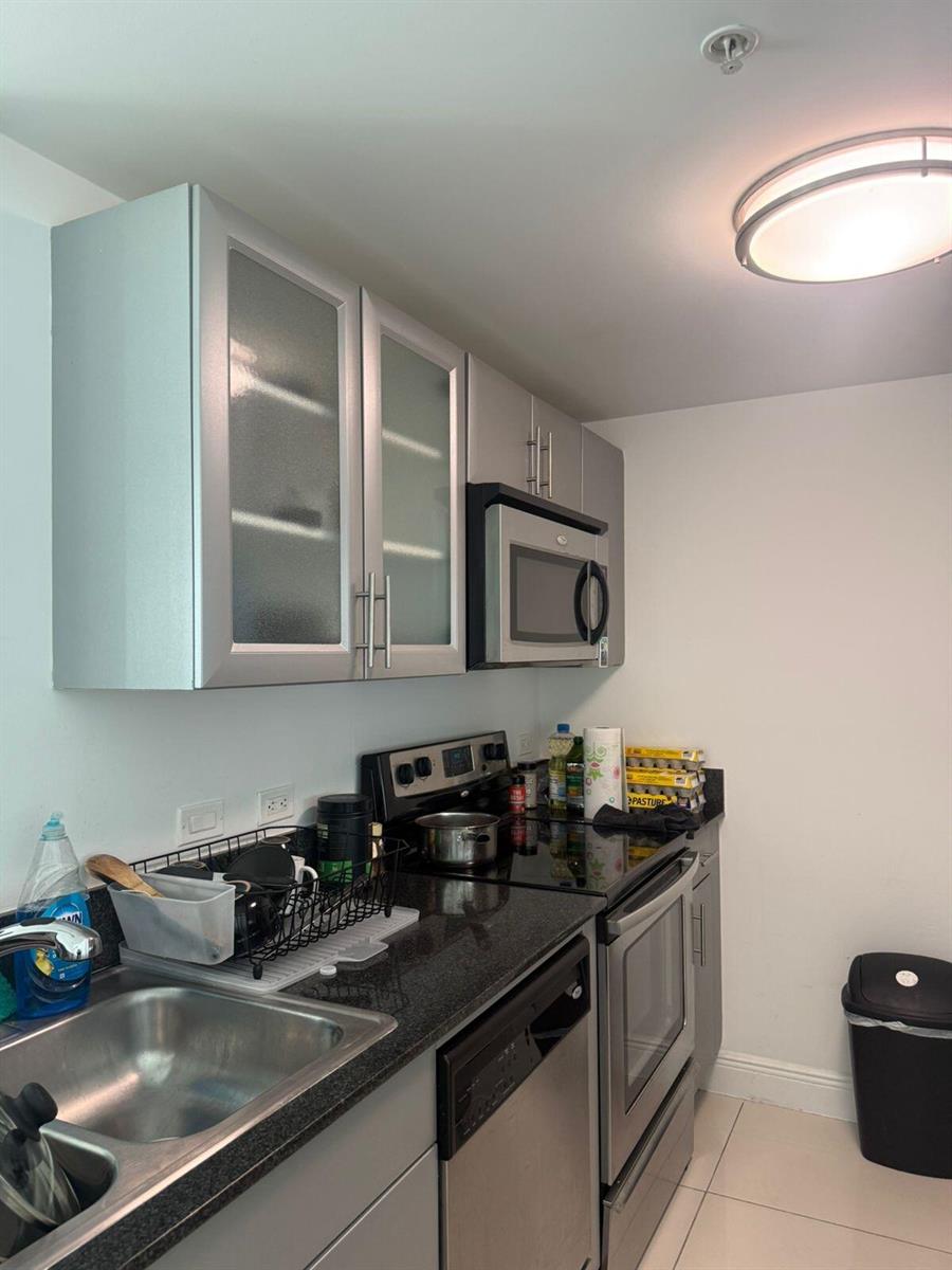 A kitchen features silver cabinets, stainless steel appliances, and black granite countertops — 1861 NW S River Drive # 2408, Miami FL 33125, MIAMI, FL