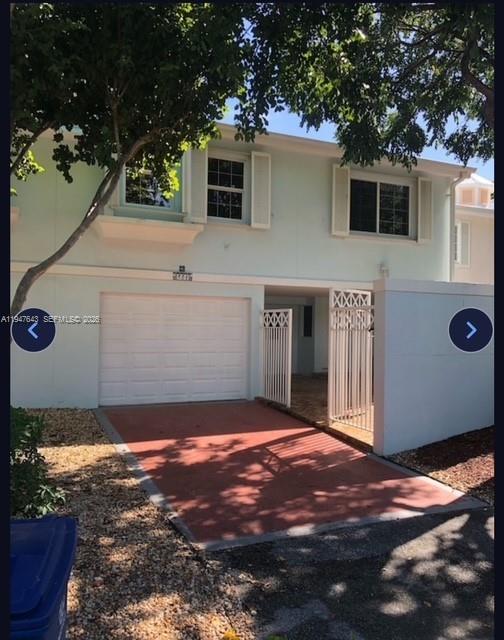 A two-story light blue townhouse with a single-car garage and a gated side entrance — 97501 Overseas Hwy # 906, Key Largo FL 33037, KEY LARGO, FL