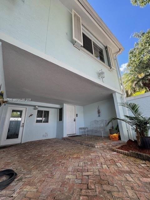 A light blue two-story house features a brick-paved patio and a covered entryway — 97501 Overseas Hwy # 906, Key Largo FL 33037, KEY LARGO, FL