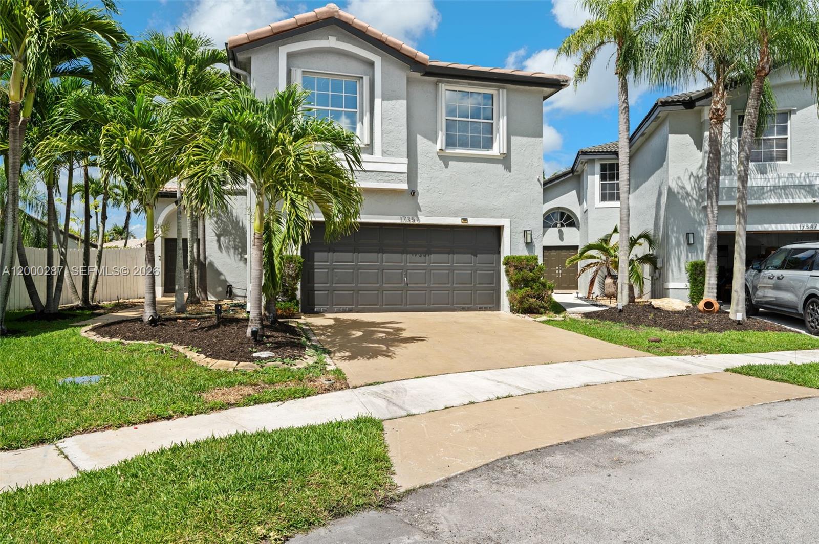 A two-story gray house with a two-car garage, palm trees, and a concrete driveway — 17357 SW 20th Ct, Miramar FL 33029, MIRAMAR, FL
