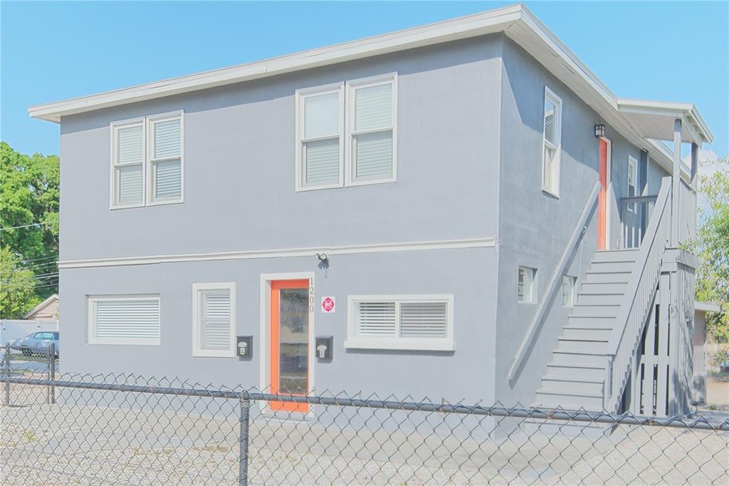 A two-story gray apartment building with an exterior staircase and orange-framed doors — 1200 40TH STREET S, ST PETERSBURG, FL