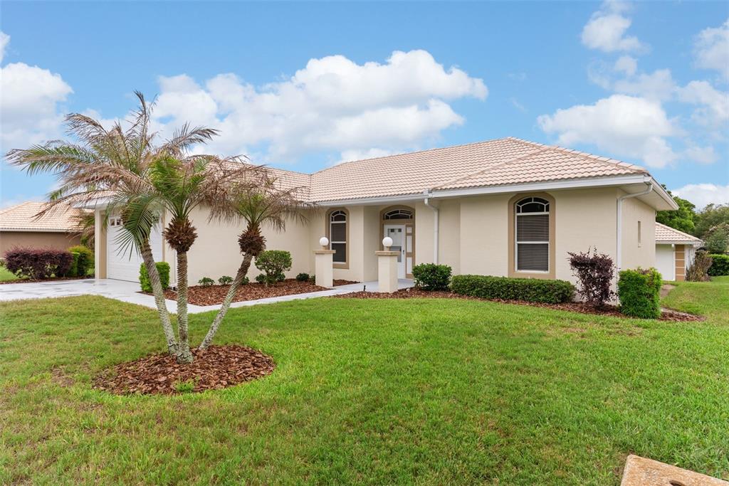 A single-story house with a beige exterior, tile roof, and a palm tree in the yard — 117 HARBOR WAY, AUBURNDALE, FL