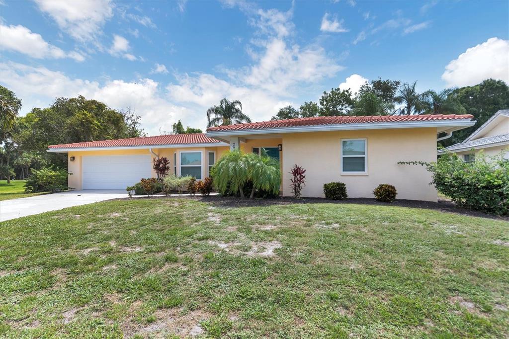 A single-story house with a light-colored exterior, red tile roof, and a two-car garage — 2943 TUCKERSTOWN DRIVE, SARASOTA, FL