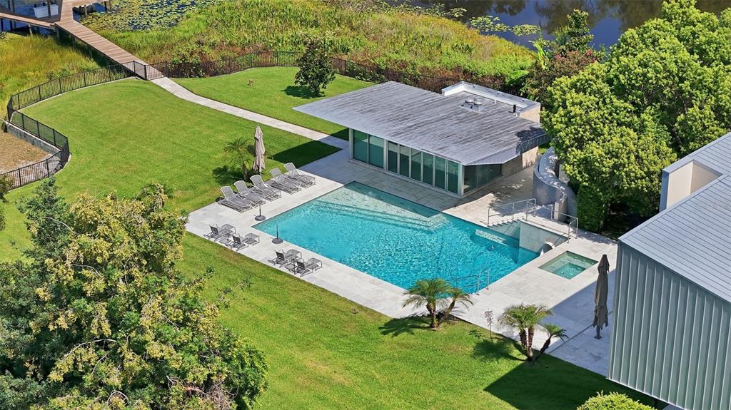 An aerial view shows a swimming pool, spa, and modern pool house on a lawn — 2821 LINTHICUM PLACE, TAMPA, FL