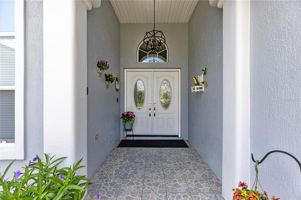 A covered entryway features a double front door with glass inserts and a tile floor — 6744 SW 113TH PLACE, OCALA, FL