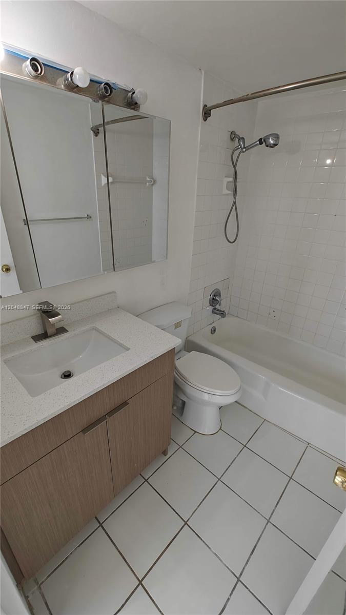 A bathroom features a wood-toned vanity, white countertop, toilet, and a tiled shower-tub combination — 801 Brickell Bay Dr # 365, Miami FL 33131, MIAMI, FL