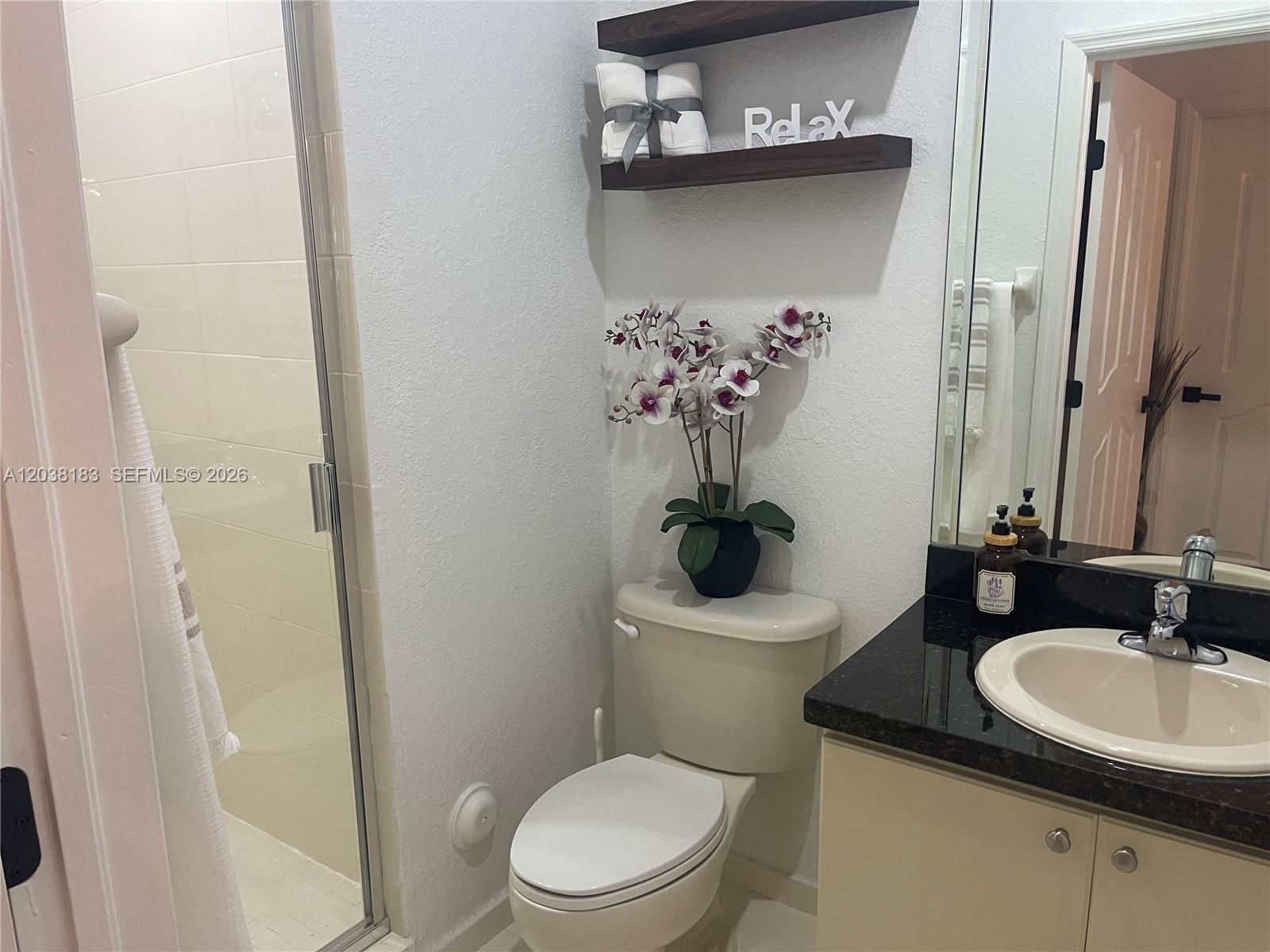 A bathroom features a toilet, a vanity with a dark countertop, and a glass-enclosed shower — 16364 SW 44th Way, Miami FL 33185, MIAMI, FL