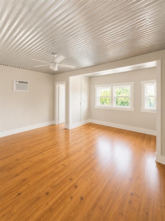An empty room features a corrugated metal ceiling, wood flooring, and a ceiling fan — 2316 N HIGHLAND AVENUE, TAMPA, FL