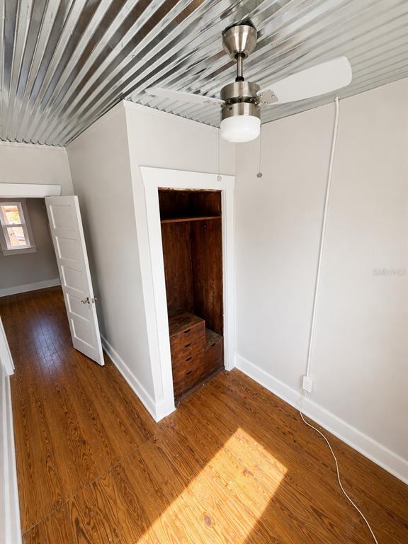A room with hardwood floors, a corrugated metal ceiling, a ceiling fan, and an open closet — 2316 N HIGHLAND AVENUE, TAMPA, FL