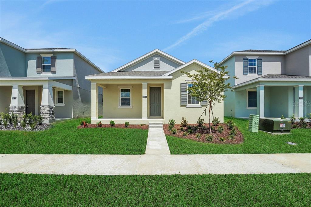A single-story house with a yellow stucco exterior, a front porch, and a concrete walkway — 5213 WAYPOINTE BOULEVARD, APOPKA, FL