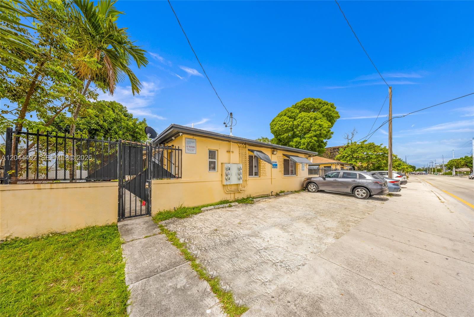 A single-story yellow building with a gated entrance and a paved parking area — 1731 SW 8th St, Miami FL 33135, MIAMI, FL